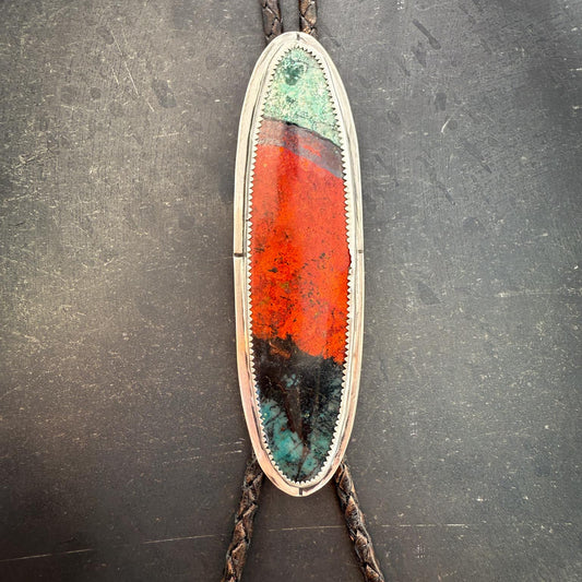 Bolo tie with a colorful oval stone on a dark gray background