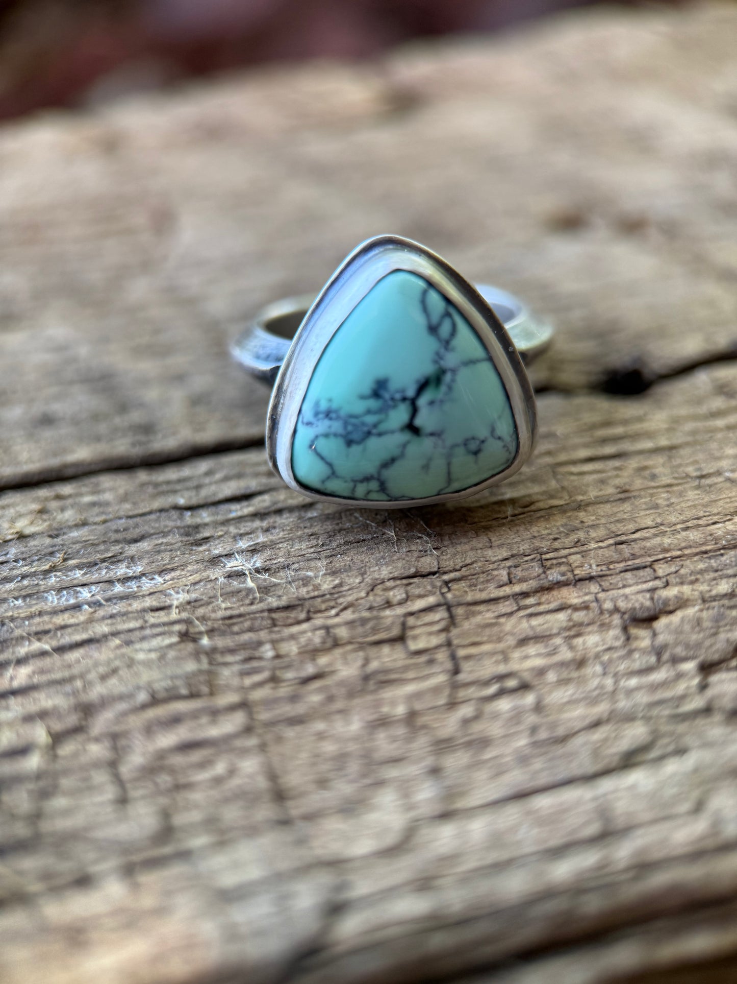 variscite ring with black matrix on wood background 