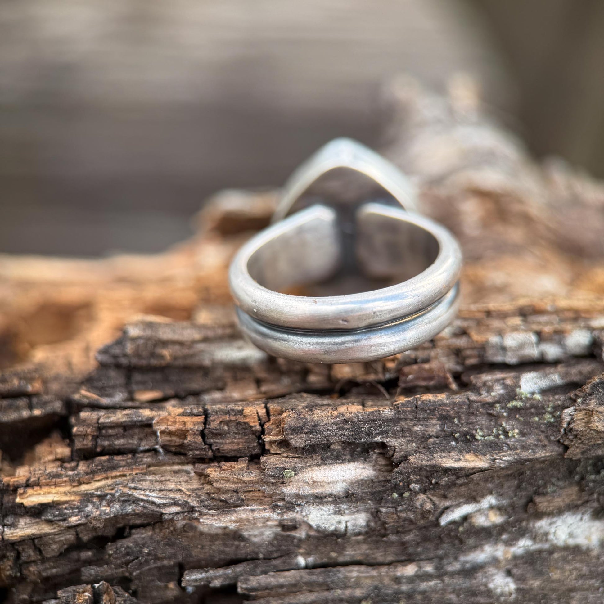 Silver ring on a textured wooden surface