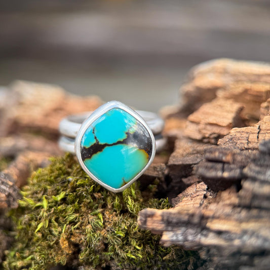 Turquoise ring on a piece of wood with moss