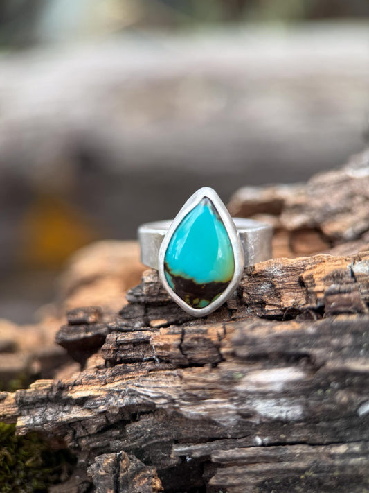 Turquoise ring on a piece of wood with a natural background