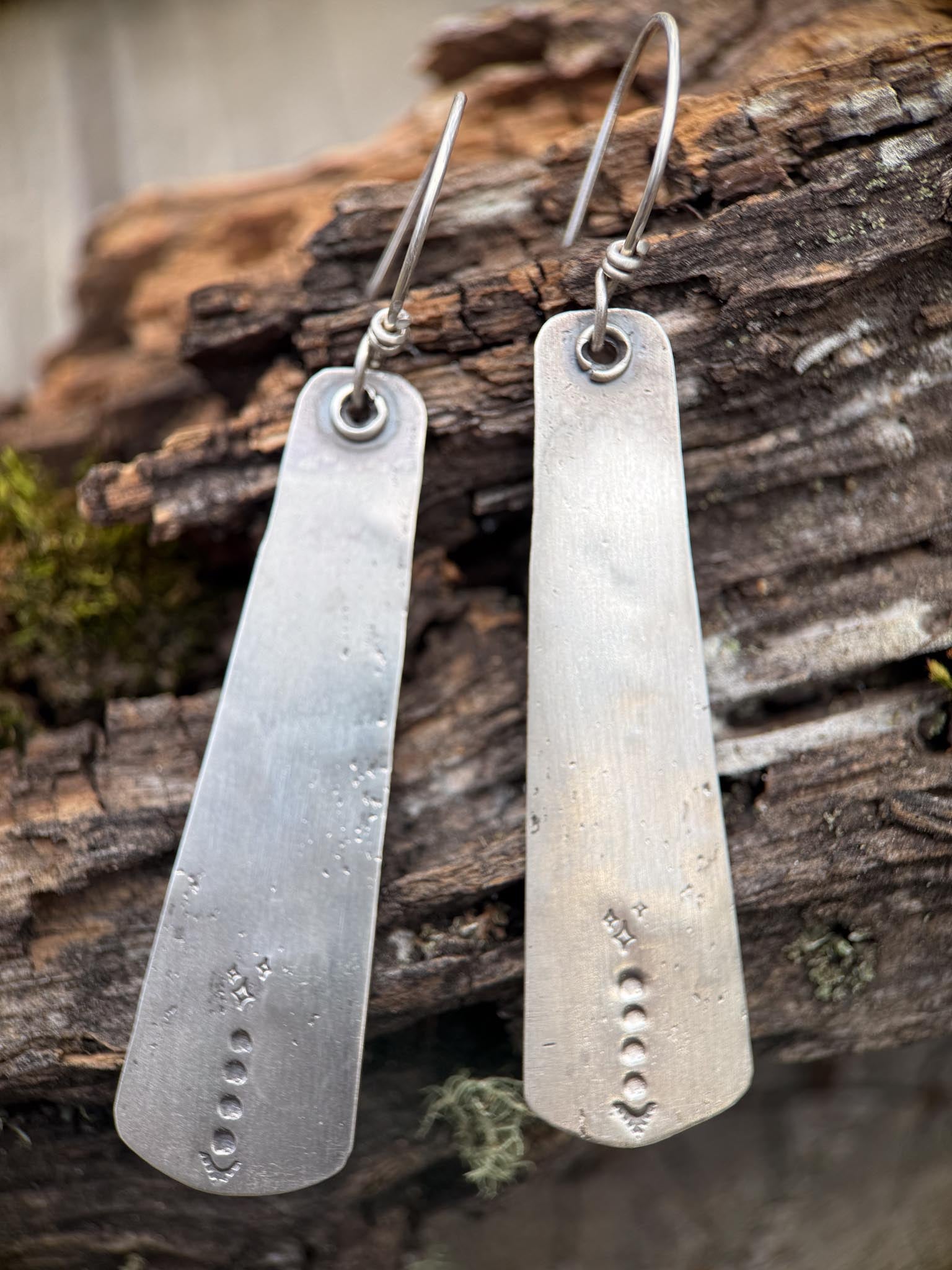 Pair of silver earrings on a wooden surface
