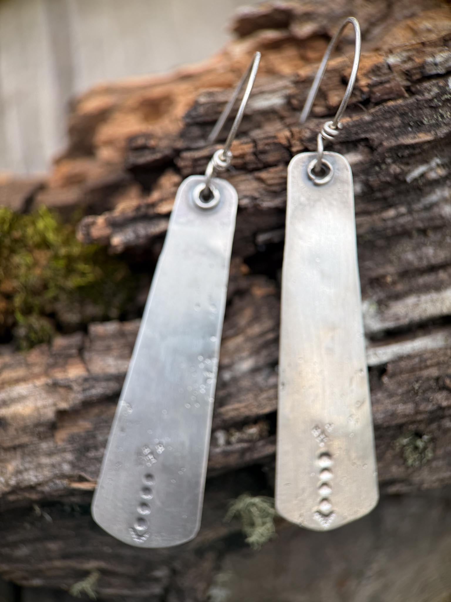 Silver earrings on a wooden surface