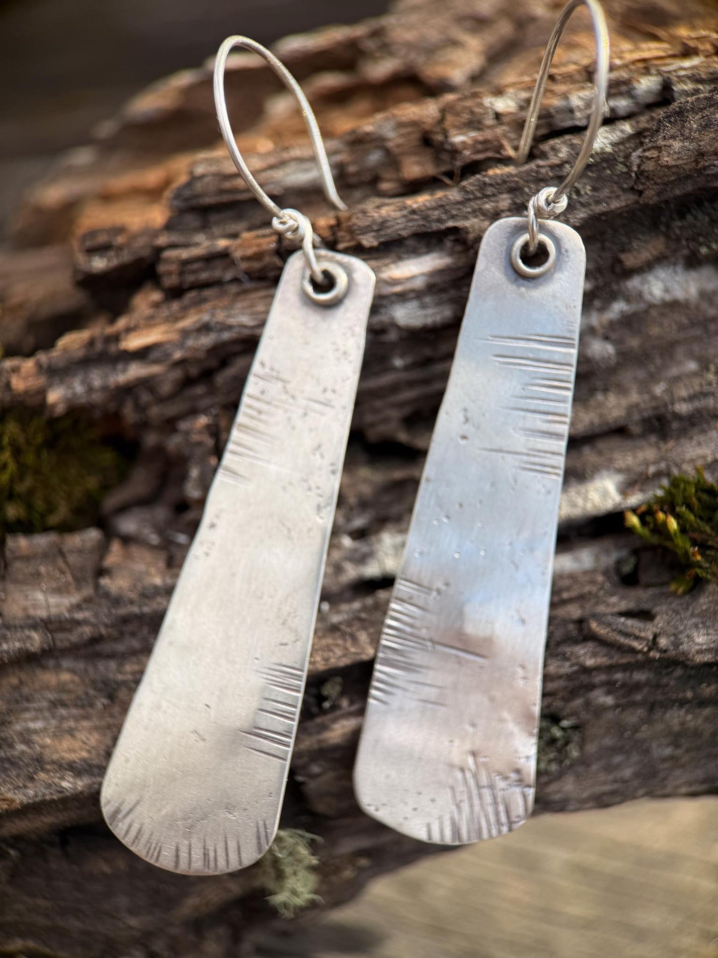 Pair of silver earrings on a wooden surface
