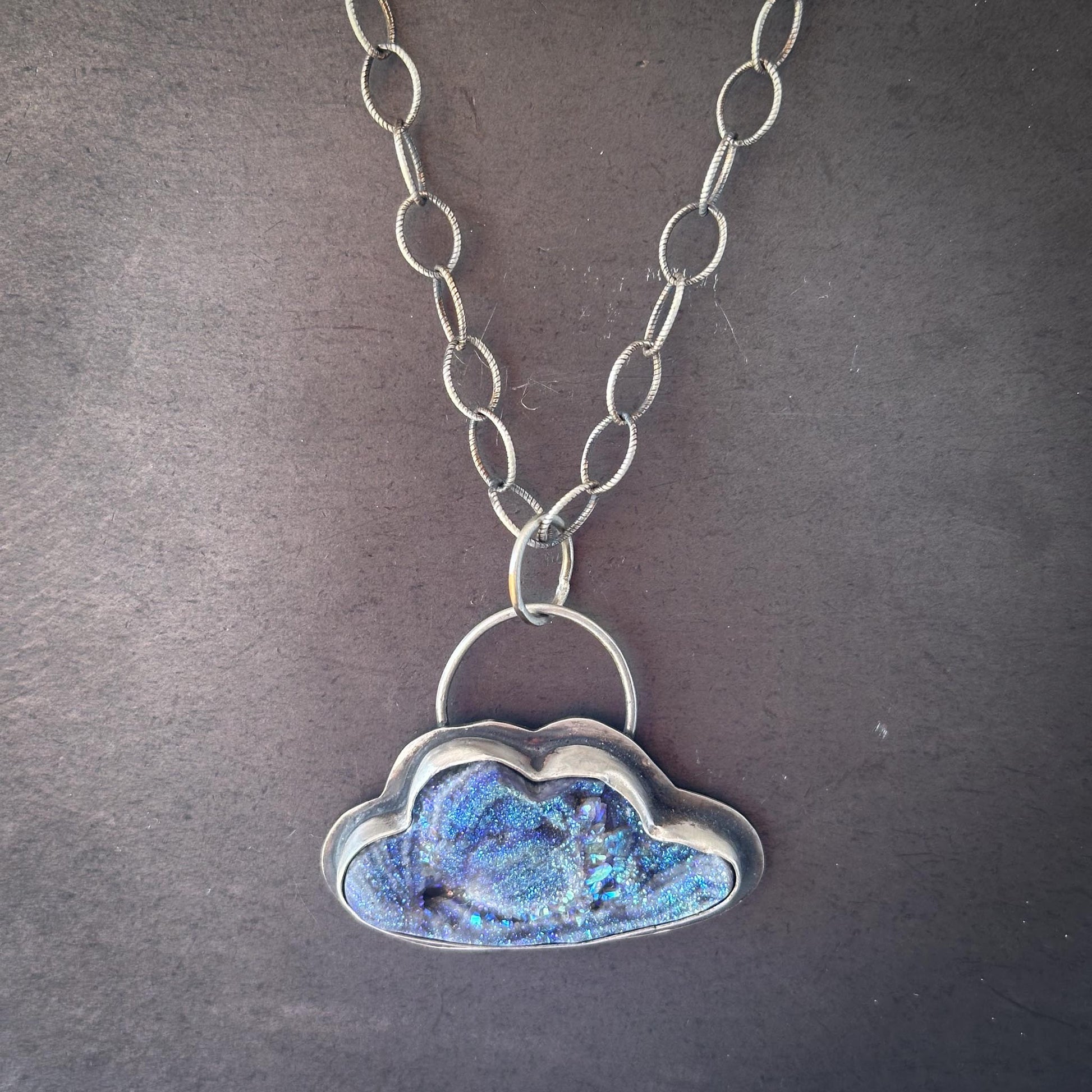 Sparkly cloud-shaped pendant with rainbow-like silver bale on oxidized oval chain – handmade by Mend Metalworks