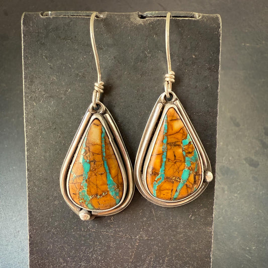 Teardrop-shaped earrings with Royston ribbon  turquoise stones on a dark gray background