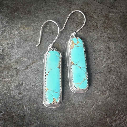 Glacier Blue turquoise vertical bar earrings with teal color, light brown matrix, and sterling silver serrated bezel